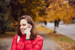 © Марина Шемедюк - girl sitting on the walkway in the autumn park in a red jacket