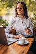 © eastwest photo - businesswoman working on laptop in cafe