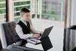 © muse studio - school white shirt and stylish hairstyle studying on a computer laptop, doing lessons online with a teacher. smart schoolboy boy with dark hair of European appearance.