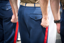 Clenched Fists Of US Marine Corpsman Standing At Attention During A Daytime Ceremony.