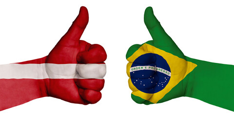 Two hands with a raised finger. They portray the gesture class, managed to negotiate. On the hands of the image of the flags of the countries, Brazil and Latvia