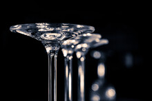 Detail Of Three Glasses Standing Upside Down On A Dark Background . Black And White Photography