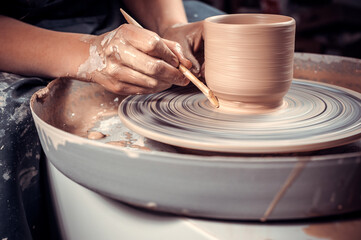 Wall Mural - The process of making a clay jug on a potter's wheel. Close-up.