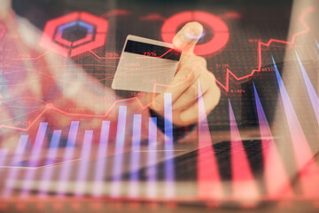 Double exposure of man hands holding a credit card and Forex graph drawing. Stock trading and digital fintech in Internet E-commerce concept.