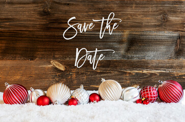 Wall Mural - English Calligraphy Save The Date On Rustic Brown Wooden Backgroud. Red And White Festive Christmas Ball Ornament On Snow.