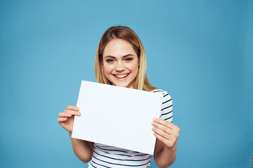 Emotional woman holding a sheet of paper in her hands lifestyle close-up blue background Copy Space