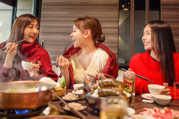 Wall Mural - happy young friends  having fun in hot pot restaurant