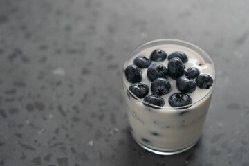 Wall Mural - greek yogurt with blueberries and granola in glass on concrete background