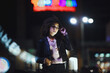 © VERSUSstudio - Fashionable woman on urban city street at night