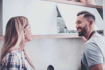 Wall Mural - happy couple discussing something sitting on the kitchen floor