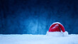 Nikolausmütze vor dunklem Hintergrund im Schnee