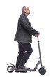 © ASDF - side view . Mature man with electric scooter looking forward