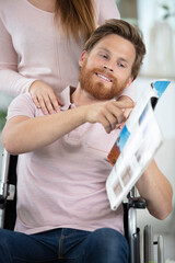 disabled man showing travel brochure to his girlfriend