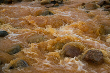 The Rapids. Unique Yellow River Due To The Presence Of Iron Mineral In Water. Closeup View Of The Water Flowing Along The Rocky River Bed. 