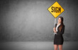 © ra2 studio - Young business person holding road sign with SIGN inscription, new rules concept