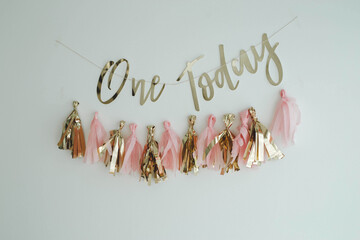 Closeup shot of tassel garland and 'One today' text on the wall