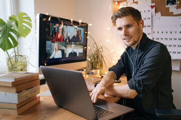 Young man having Zoom video call via a computer in the home office. Stay at home and work from home concept during Coronavirus pandemic. Telework