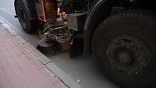 Street Sweeper Machine Cleans Town Street With Brushes. Roadway Cleaning Machine. Cleaning Machine Brush Removing Yellow Fallen Leaves From The Autumn Street.