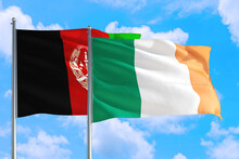 Ireland And Afghanistan National Flag Waving In The Wind On A Deep Blue Sky Together. High Quality Fabric. International Relations Concept.