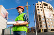 © F8  \ Suport Ukraine - Young engineer builder with blueprint plan at construction site outdoors