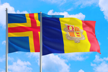 Andorra and Aland Islands national flag waving in the windy deep blue sky. Diplomacy and international relations concept.