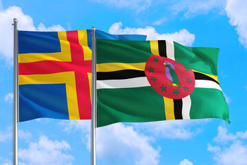 Dominica and Aland Islands national flag waving in the windy deep blue sky. Diplomacy and international relations concept.