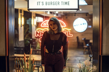 Canvas Print - Closeup shot of a cool attractive blue-haired young lady posing in front of a cafe