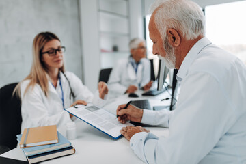 Wall Mural - An elderly patient talking with his doctor about the medications he should use.