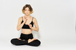 © SHOTPRIME STUDIO - woman in dark clothes sitting on the floor and meditation exercises for legs leggings