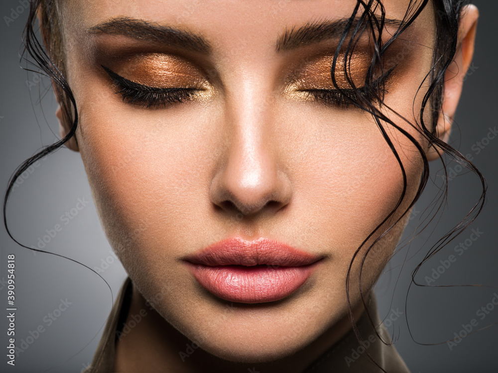 Closeup portrait of a beautiful young fashion woman with glamour makeup posing at studio. - obrazy, fototapety, plakaty 