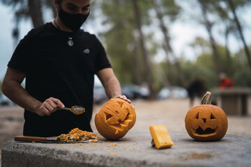 Canvas Print - Man carving and preparing a pumpkin for Halloween