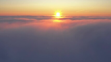 Wall Mural - crossing the clouds during sunrise, aerial flight above clouds during golden hour in sunrise light.
