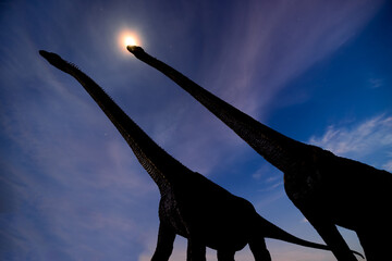 two silhouette dinosaur in dark night and moon halo  background