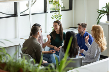 Wall Mural - Business training. Group of positive inspired professional employees managers teammates sitting in circle at office space providing meeting training briefing, creating ideas, talking, sharing opinions