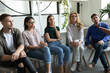 © fizkes - Attentive listeners. Group of people of diverse age gender race sitting on office chairs in meeting room listening to lecture training course consultation provided by qualified teacher trainer coach