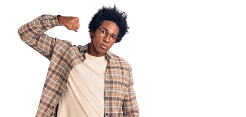 Sticker - Handsome african american man with afro hair wearing casual clothes and glasses strong person showing arm muscle, confident and proud of power