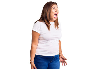 Middle age latin woman wearing casual white tshirt angry and mad screaming frustrated and furious, shouting with anger. rage and aggressive concept.