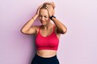 © Krakenimages.com - Beautiful caucasian woman wearing sportswear suffering from headache desperate and stressed because pain and migraine. hands on head.