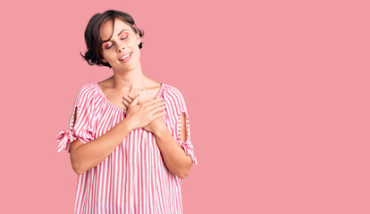 Sticker - Beautiful young woman with short hair wearing casual summer clothes smiling with hands on chest with closed eyes and grateful gesture on face. health concept.