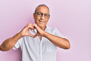 Sticker - Handsome mature senior man wearing casual shirt and glasses smiling in love doing heart symbol shape with hands. romantic concept.