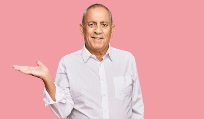 Sticker - Handsome senior man wearing elegant white shirt smiling cheerful presenting and pointing with palm of hand looking at the camera.