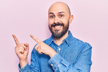 Wall Mural - Young handsome man wearing casual clothes smiling and looking at the camera pointing with two hands and fingers to the side.