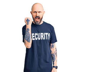 Poster - Young handsome man wearing security t shirt angry and mad raising fist frustrated and furious while shouting with anger. rage and aggressive concept.