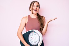 Beautiful Young Caucasian Woman Holding Weight Machine To Balance Weight Loss Celebrating Victory With Happy Smile And Winner Expression With Raised Hands