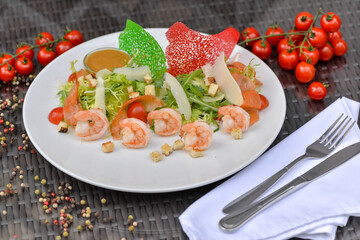 Wall Mural - fresh salad with shrimp cherry tomatoes in a plate on a table with decor
