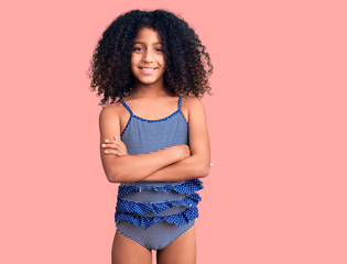 African american child with curly hair wearing swimwear happy face smiling with crossed arms looking at the camera. positive person.