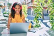 © Krakenimages.com - Young african american student girl using laptop sitting on the table at terrace.