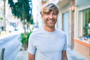 Canvas Print - Young irish man smiling happy walking at street of city.