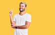 © Krakenimages.com - Young handsome blond man wearing casual t-shirt with a big smile on face, pointing with hand and finger to the side looking at the camera.