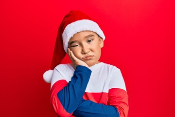 Canvas Print - Little boy hispanic kid wearing christmas hat thinking looking tired and bored with depression problems with crossed arms.